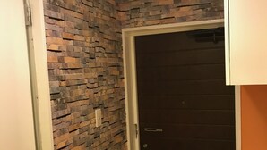 A hallway with a stone wall and a dark door. - only 2 stops to SHIBUYA, free pocket wifi provided (世田谷区)