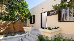 A boutique hotel named "ARAMIS" with a modern facade, a wooden fence, and a small garden area with steps leading to the entrance. - Aramis Boutique House, Medieval Old-Town Rhodes (Rodos)