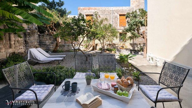 A patio with a table set for breakfast, including fruits, pastries, and drinks. - Aramis Boutique House, Medieval Old-Town Rhodes (Rodos)