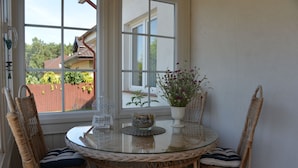 A round glass table with wicker chairs, a vase with flowers, and a bowl on a windowsill. - Casa Azul Seaside House 10 minutes from Gdynia, 25 minutes from Gdańsk. 15 min. Sopot (Kosakowo)
