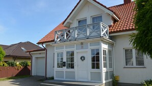 A two-story house with a balcony, a front door, and a garage. - Casa Azul Seaside House 10 minutes from Gdynia, 25 minutes from Gdańsk. 15 min. Sopot (Kosakowo)