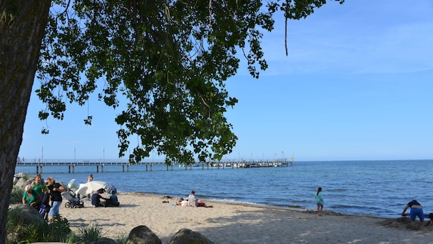 A beach with people, a pier in the background, and large rocks in the foreground. - Casa Azul Seaside House 10 minutes from Gdynia, 25 minutes from Gdańsk. 15 min. Sopot (Kosakowo)