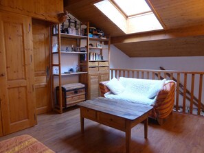 Un dormitorio tipo loft con tragaluz, muebles de madera y una estantería empotrada.