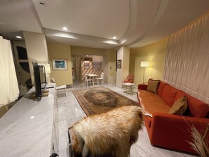 Relax in this stylish living room with a sofa, dining area, and comfortable seating.