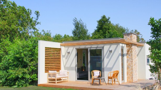 A modern house with a patio, two wicker chairs, and a glass door leading inside. - Holiday home Callants` Lodge (Callantsoog)