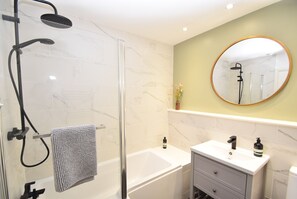 Bathtub, hair dryer, towels, toilet paper