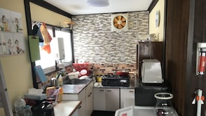 Una cocina compacta con salpicadero de azulejos, estufa, pileta y refrigerador.