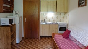 A compact kitchen with a microwave, coffee maker, sink, and stove. - Cozy 30m² Apt for 4 at Planay Slopes avec Balcony, Parking & Heated Ski Room (Arêches-Beaufort)