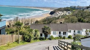 Zona residencial costera con casas, una playa y cielo despejado.