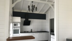 Eine moderne Küche mit weißen Schränken, einer schwarzen Spritzschutzwand und einer Holzarbeitsplatte.