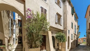 A narrow street with buildings featuring stone facades, arched doorways, and small steps leading to entrances. - Panoramic views of Monaco and the Mediterranean (Roquebrune-Cap-Martin)