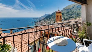 A balcony with a view of the sea, a tower, and terracotta rooftops. - Panoramic views of Monaco and the Mediterranean (Roquebrune-Cap-Martin)