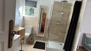 A modern bathroom with a shower, toilet, and sink.