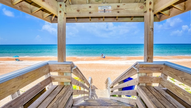 Un abri de plage en bois offrant une vue sur l’océan.