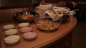 A buffet table with various food items and bowls of different sauces. - Garnì Eden (Canazei)