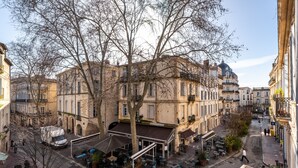 A street view with buildings, outdoor seating, and a café.