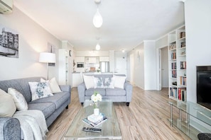 Una sala de estar moderna con un sofá, una mesa de centro y una estantería.