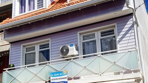 Un edificio de dos pisos con un balcón, un letrero que dice 'Piment Rose' de lencería y un letrero que indica 'St. Anne'.