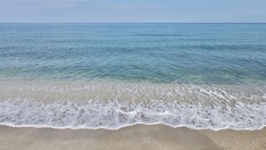 Uma praia com águas cristalinas e ondas suaves.