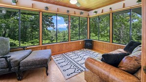 A room with large windows, a ceiling fan, and a fireplace. - Spectacular Views! -Great Location-Hot Tub-Dreamy Porch & Sun Room-Fenced Yd! (Arden)