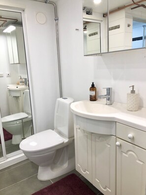 Kombination af bruser/badekar, hårtørrer, hjemmesko, håndklæder