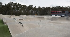 A skatepark with various ramps and a building labeled "BOULCENTER" in the background. - Apartment in basement (Skogstorp-Västra Gärdet-Arvidstorp)