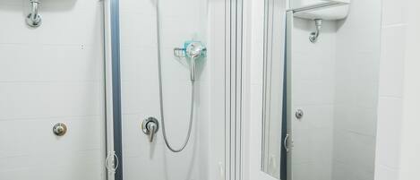 Uma casa de banho moderna com sanita, lavatório e chuveiro.
