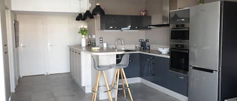 A modern kitchen with a built-in island, stainless steel appliances, and a minimalist design.
