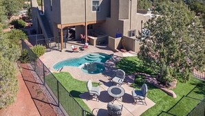 Una casa moderna con piscina, area salotto esterna e vista sulle montagne.