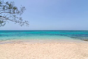 A beach with clear turquoise water and sandy shore. - Hospitality Expert CP (Montego Bay)