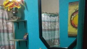 Un baño con lavamanos, espejo y perchero.