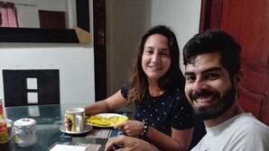 Una mesa de comedor con platos de comida, una taza y un pequeño recipiente.