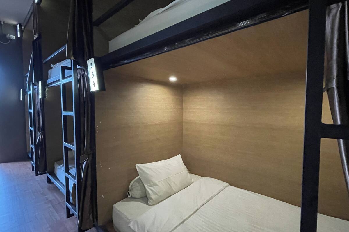 Habitación con literas, cabecera de madera y una cama individual.