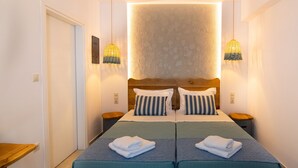 A double bed with two pillows, a bedside table, and a wall-mounted light fixture.