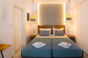 A double bed with two pillows, a bedside table, and a wall-mounted light fixture. - Varkotopi villa 5,Pool,Near the Beach,South Crete (Rethymno)