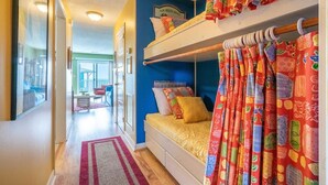 A bunk bed room with colorful curtains, a window, and a view of the outside. - ☀️Riggings K3-Beautiful Location and Views-Oceanfront Complex w/ Pool☀️ (Kure Beach)