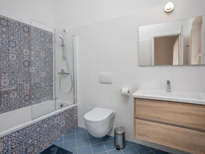A bathroom with a shower, toilet, and vanity.