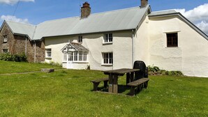 A white building with a sloped roof, a small window, and a chimney. - Well Farmhouse - UK11880 (Holsworthy, near Launceston)
