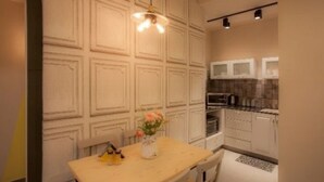 Una cocina con armarios blancos, encimera de madera y un florero con flores.