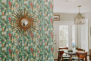 Enjoy meals in this stylish dining area with a wooden table and chairs, surrounded by a unique sunburst wallpaper.