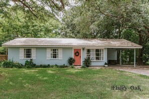 Welcome to Eisley Oak, a charming single-story home with a cozy porch and beautifully manicured lawn.