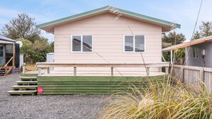 Une maison de plain-pied avec un toit végétalisé et une terrasse en bois.