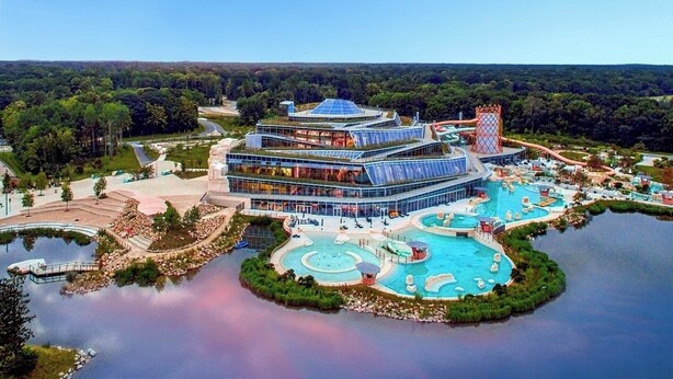 Ein Resort mit einem großen Gebäude, mehreren Swimmingpools und einer umliegenden Naturlandschaft.