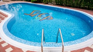 A swimming pool with a tiled edge and a metal ladder leading into the water. - Step (Sunny Beach)