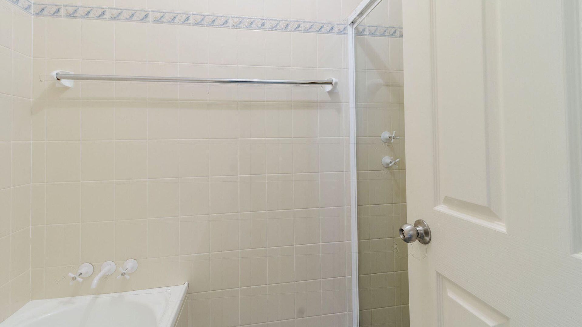 Een badkamer met een douche, toilet en wastafel.