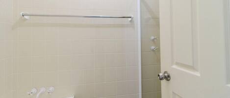 Een badkamer met een douche, toilet en wastafel.