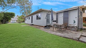 A mobile home with a small patio area, a table, and chairs. - Enjoy the soothing sea breeze (Hawks Nest)