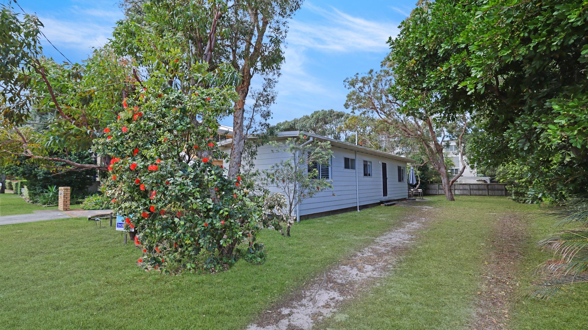 A single-story mobile home with a small deck and a garden area.
