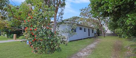 A single-story mobile home with a small deck and a garden area.