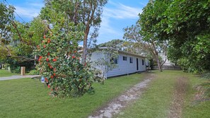 A single-story mobile home with a small deck and a garden area.